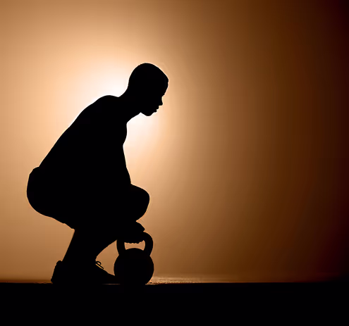 A silhouette of a man holding a kettle.