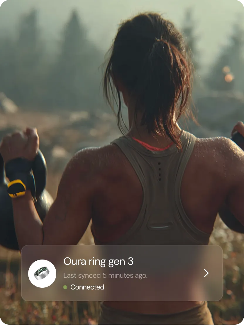 Woman lifting kettlebells outdoors, showing sweaty back and fitness activity.