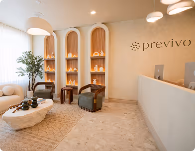 Modern reception area with Previvo logo, cozy seating, plants, and decorative shelves with candles.