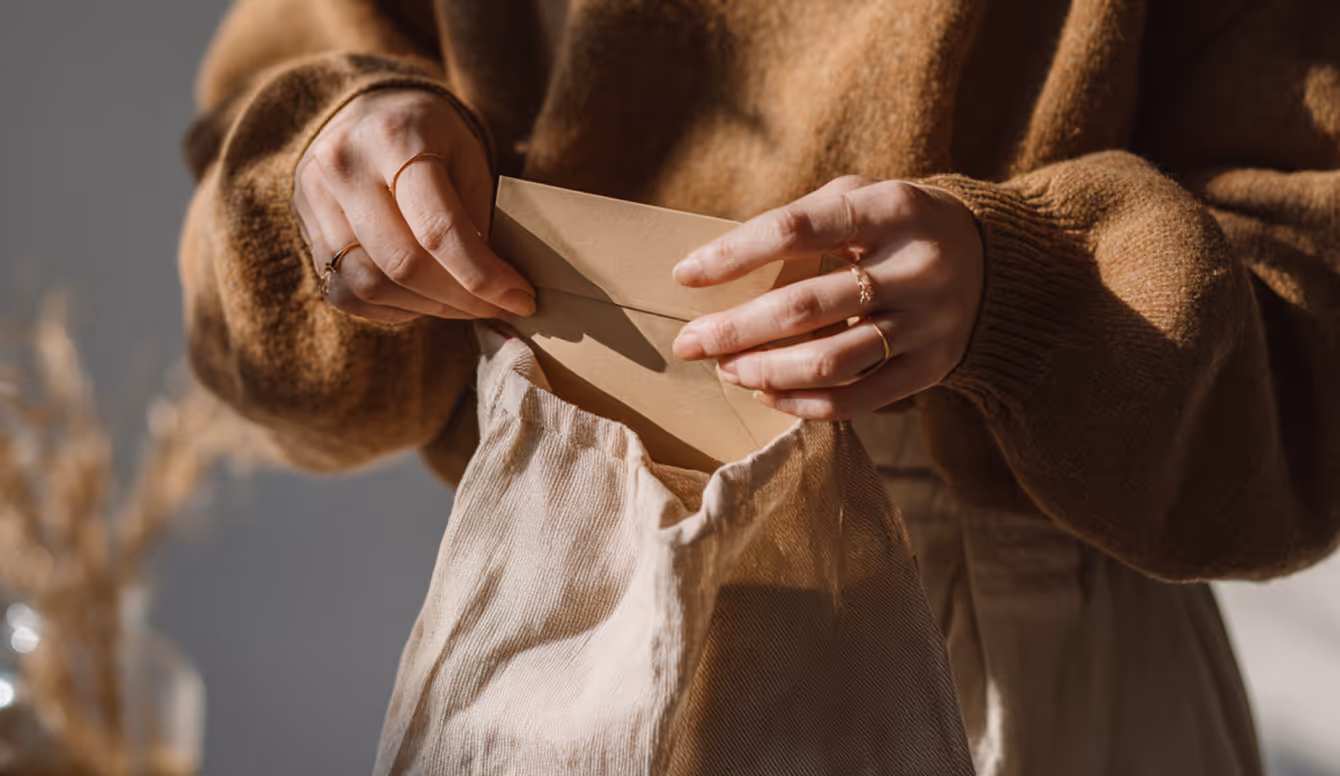 Hands holding a small folded paper packet