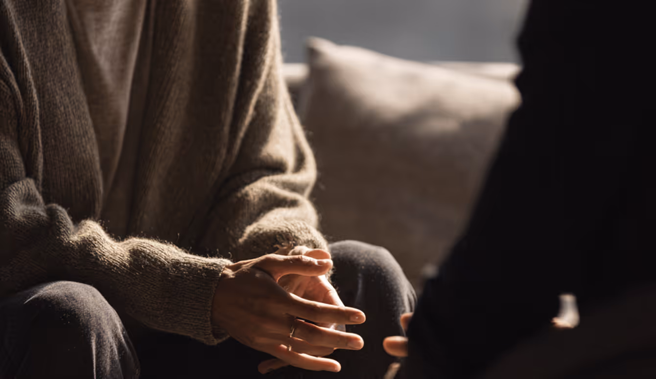 Man gesturing while seated in a consultation