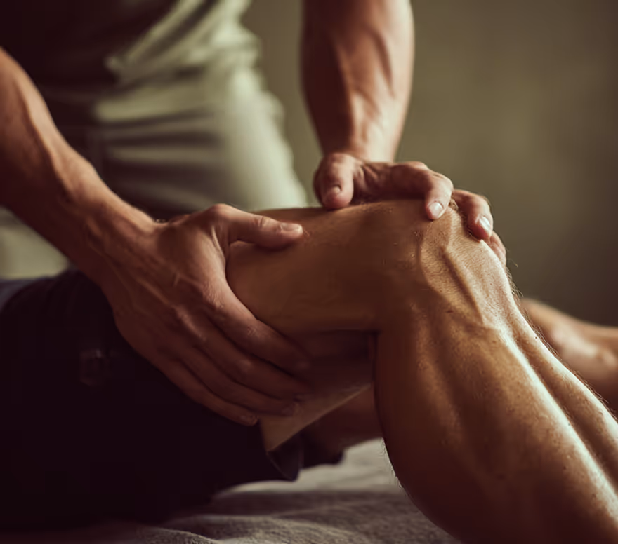 Practitioner massaging a client's bent knee