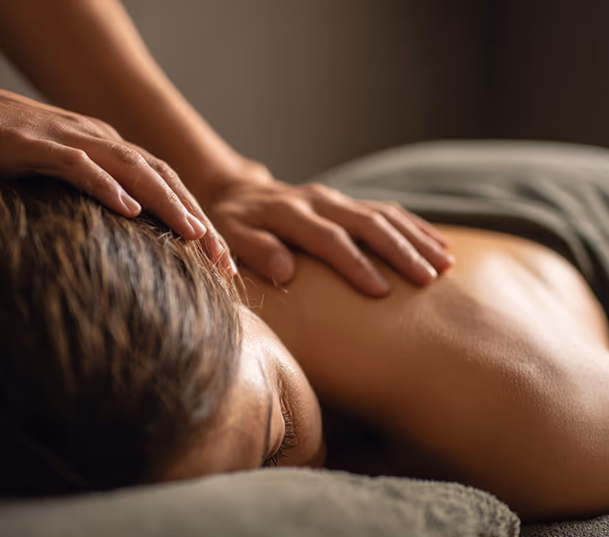 Hands applying massage to a client's upper back