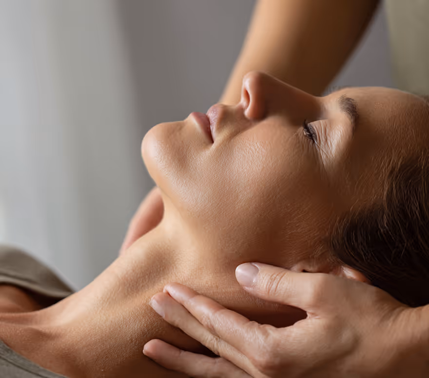 Hands applying massage around a client's neck