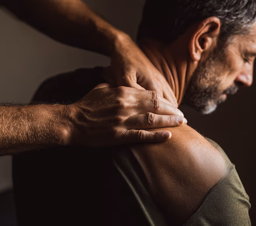 Practitioner applying pressure to a client's shoulder